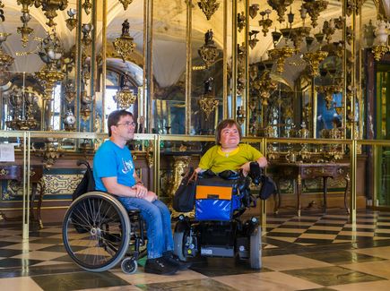 Two people in wheelchairs visiting the Green Vault in Dresden.