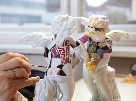 Person painting a porcelain figure in Meissen