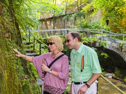 Two people with visual impairment hiking in Saxon Switzerland.