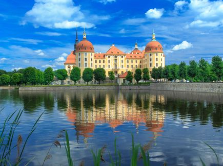 View of Moritzburg Castle in the sun, with the castle pond in the foreground.